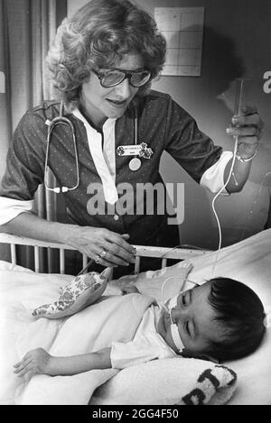 Austin Texas USA, circa 1990: Nurse checks on child in children's hospital, Austin.  NO ID's no releases Stock Photo