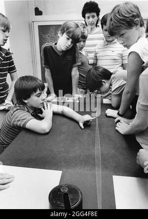 Austin Texas USA, circa 1994: Middle school boys work on physics problems with vibrating string at a summer science camp for high-achieving students. ©Bob Daemmrich Stock Photo