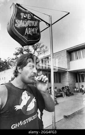 Austin Texas USA, circa 1985: Male transient smoking a cigarette outside the Salvation Army office near downtown. ©Bob Daemmrich Stock Photo