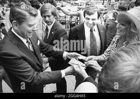 Houston Texas USA, 1980: Republican presidential candidate Ronald Reagan autographs a dollar bill for an admirer during a campaign stop in Houston. ©Bob Daemmrich Stock Photo