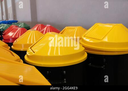 A row of large and bright multi colors plastic garbage containers. Stock Photo