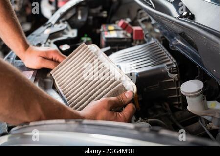 An auto mechanic is changing the air filter in the car Stock Photo