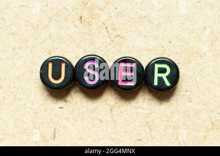 Black color round alphabet letter block in word user on wood background Stock Photo