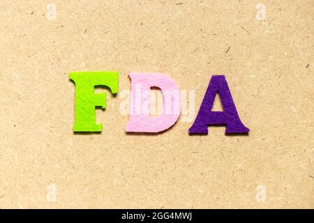 Color cloth alphabet letter in word FDA (abbreviation of food and drug administration) on wood background Stock Photo