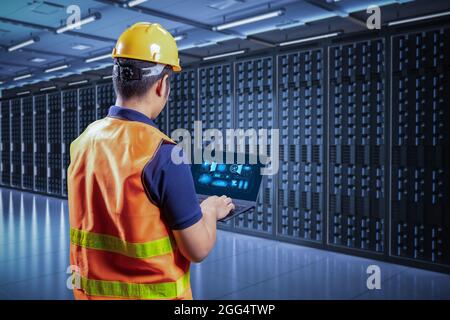 Programmer or engineer with computer notebook in server room Stock Photo