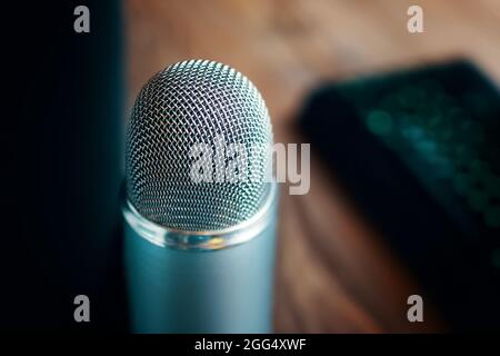 Radio show or audio podcast concept. Vintage retro old microphone for broadcast. Computer keyboard on the background. Stock Photo