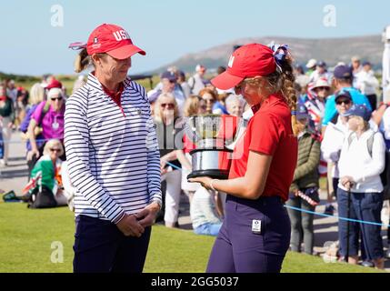 Team USA's Captain Sarah Ingram watches on as Team USA's Rachel Kuehn hold the Curtis Cup Trophy after her sides 12.5 50 7.5 victory over Team GB&I af Stock Photo