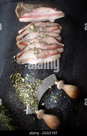 Presentation of salted pork bacon on stone slate Stock Photo