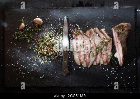 Presentation of salted pork bacon on stone slate Stock Photo