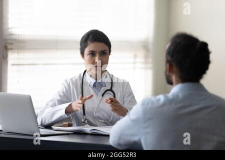 Young female indian doctor consulting african patient. Stock Photo