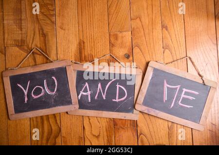 Graphic representation of the word, you and me, written with chalk on blackboard Stock Photo