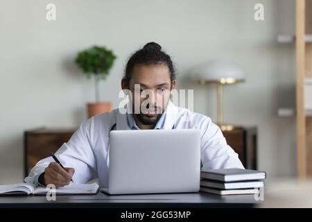 Concentrated young african american doctor working on computer. Stock Photo