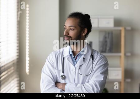 Thoughtful young male doctor looking in distance. Stock Photo
