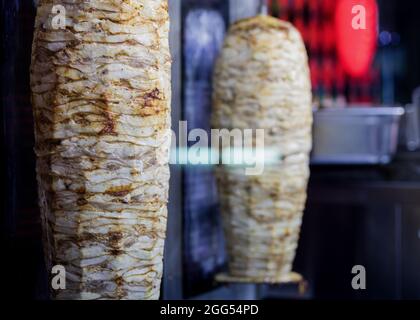 Doner kebab on rotating vertical spit. Grilled skewered chicken Stock Photo