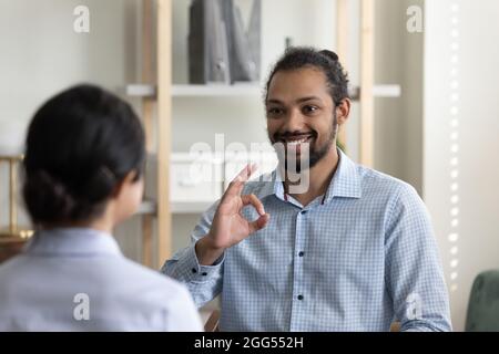 Smiling young african american man practicing sign language with doctor. Stock Photo