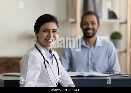 Portrait of smiling indian doctor with african patient. Stock Photo