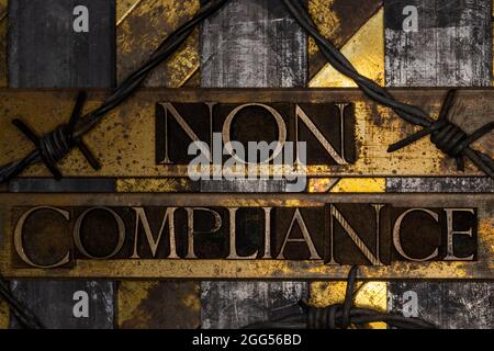Non Compliance text over barbed wire on grunge silver with textured copper and gold background Stock Photo