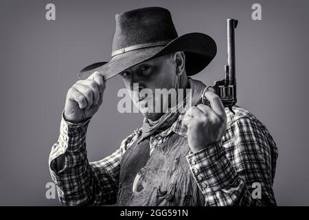 American cowboy. Cowboy wearing hat. Western life. Guy in cowboy hat. American bandit in mask, western man with hat. Man wearing cowboy hat, gun. West Stock Photo