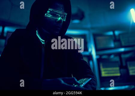 Cyber hacker breaks into databases to obtain information using a computer. Cybercrime and data security concept. Stock Photo