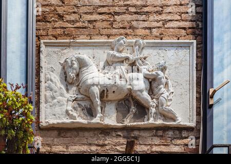 VENICE, ITALY - JUNE 15, 2016 close-up of basrelief depicting Venetian lion holding open book. Old house on Campiello De L'Anconeta, Canaregio District, Venice Stock Photo