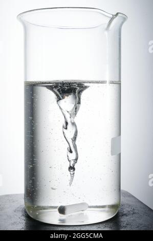 Performing chemical experiment theme. Transparent liquid in glass on magnet mixer Stock Photo