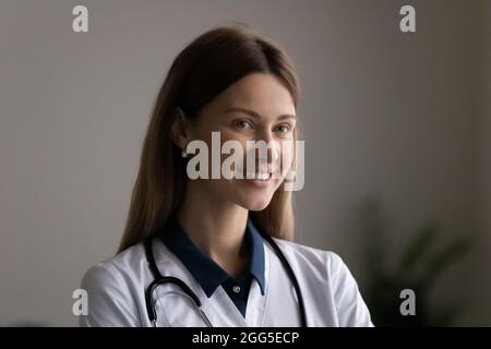 Head shot portrait of smiling dreamy female doctor. Stock Photo