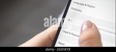 Person turn on the VPN setting on mobile phone, close-up, banner design Stock Photo