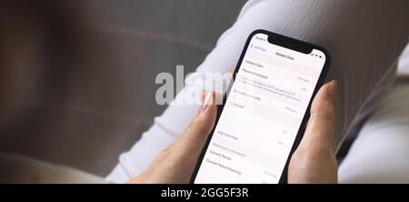 Woman switches mobile data on mobile phone. Cellular data screen and settings on the screen close-up Stock Photo