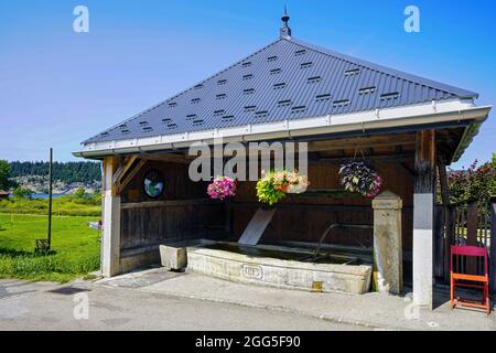 Fountain in the village of L'Abbaye. L'Abbaye is a municipality in the canton of Vaud in the Vallée de Joux. Switzerland. L’Abbaye. In the early 14th Stock Photo