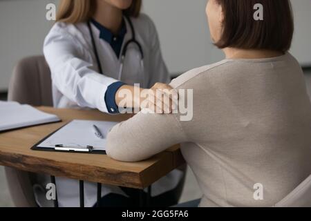 Close up young female doctor supporting older patient. Stock Photo
