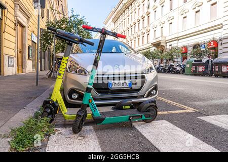 ROME ITALY UK. 29 August 2021. Electric scooters are wrongly parked  on a pedestrian crossing in front of a car in Rome.  Electric scooters have become popular in the Roman capital and are used regularly as mobility transport. Credit amer ghazzal/Alamy Live News Stock Photo