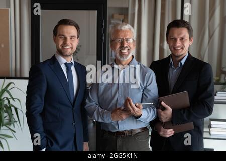 Portrait of smiling confident businessmen employees standing in office Stock Photo