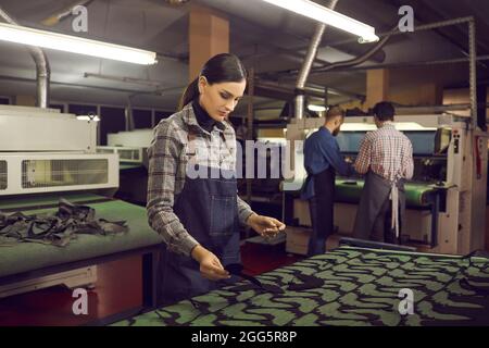 Young female shoemaker woman artisan working at workplace for shoe production Stock Photo