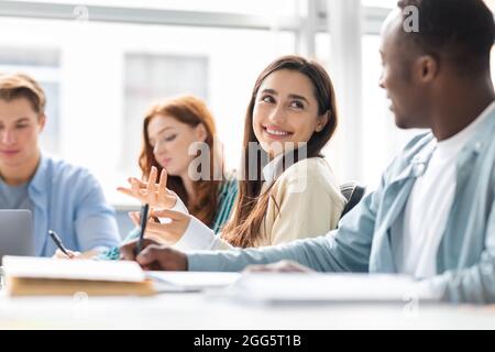 International group of people sitting at desk and talking Stock Photo