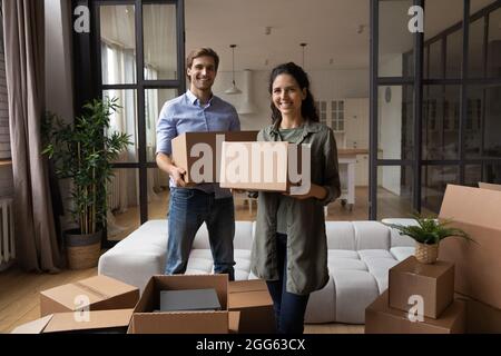 Happy beautiful young family couple posing with boxes in hands. Stock Photo