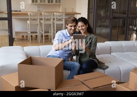 Happy young family couple using digital computer tablet. Stock Photo