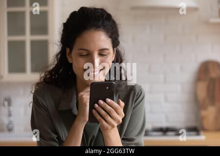 Happy young latina woman using smartphone applications. Stock Photo