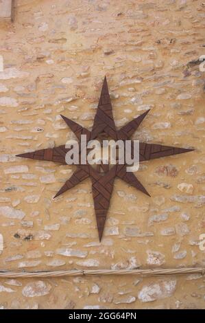 A compass rose made of dark wood and hung on a wall as a decoration Stock Photo