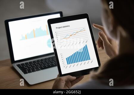 Close up businesswoman working with statistics on laptop and tablet Stock Photo
