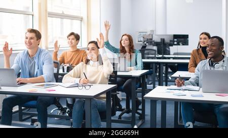 Portrait of diverse people raising hands at seminar Stock Photo