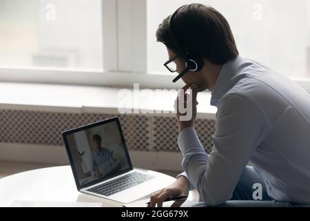 Business man in wireless headset using laptop Stock Photo