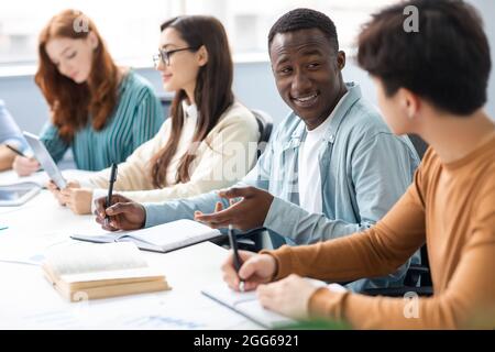International group of people sitting at desk and talking Stock Photo