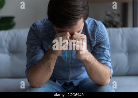 Sad frustrated millennial man suffering from stress Stock Photo