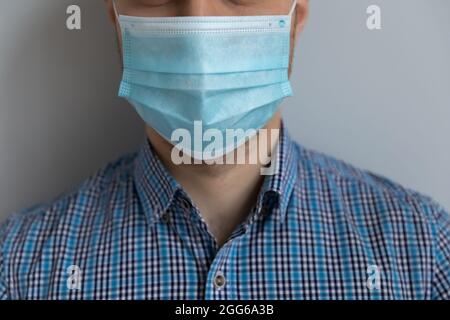 Young Caucasian man in casual wearing medical mask on face Stock Photo