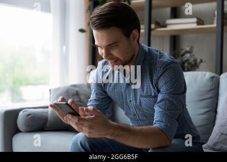 Happy mobile phone user reading text message with good news Stock Photo