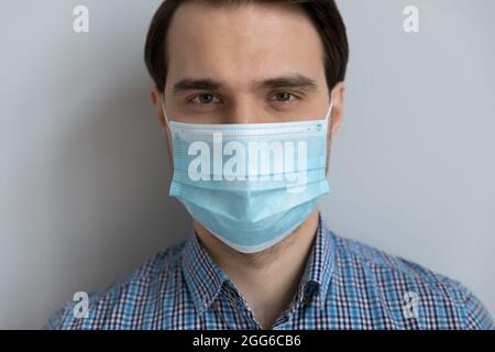 Handsome young man in medical protective mask on lower face Stock Photo