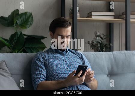 Serious mobile phone user reading text message on screen Stock Photo