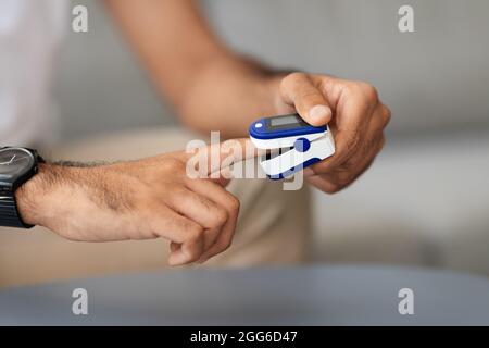 Unrecognizable man using pulse oximeter, closeup photo Stock Photo