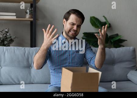 Angry dissatisfied customer receiving wrong parcel from internet store Stock Photo