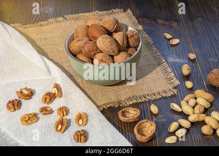 Nuts. Whole walnuts and kernels on dark rustic table Stock Photo